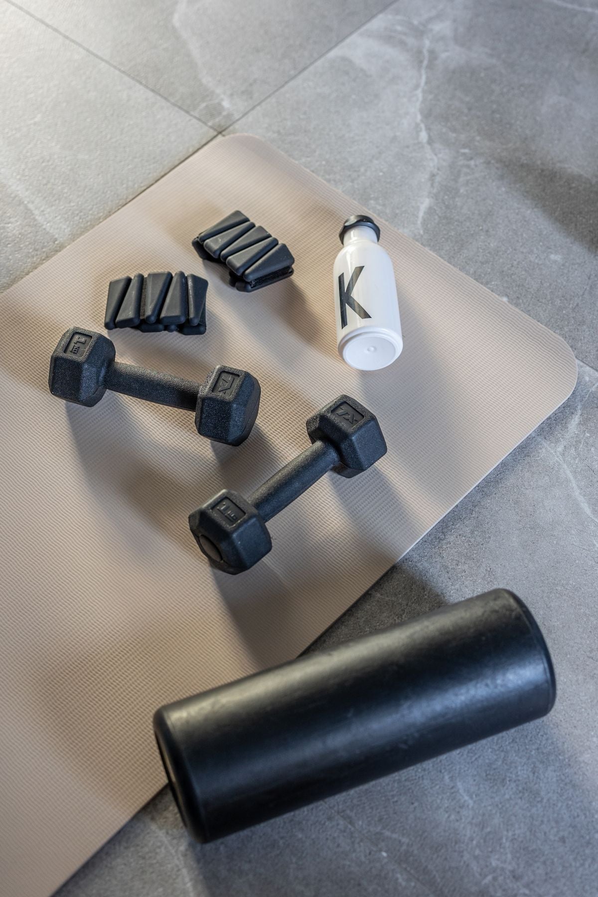 Dumbbells and a rolled yoga mat