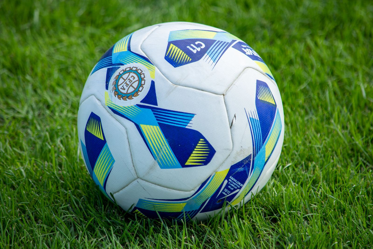 Hand-stitched match football on grass